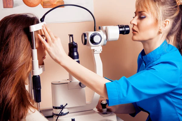 Seriöse Ärztin überprüft ihr Augenlicht auf die Patientin in der — Stockfoto