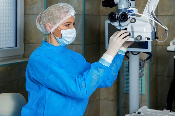 Läkaren kontroller för mikroskopet rörelseresultat före operation — Stockfoto