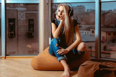 Çekici sarışın kız kulaklık müzik dinlerken ve 