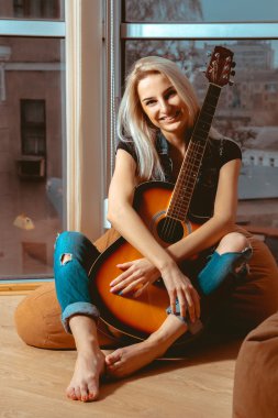 güzel genç kız elleri ve t gülümsüyor bir gitar sarılma