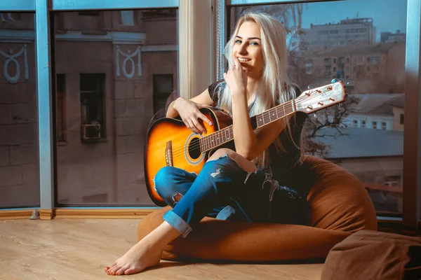 Joyeuse jeune fille blonde joue de la guitare — Photo