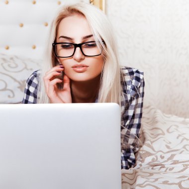 Yatakta dizüstü bilgisayar ile genç sarışın kız Kare fotoğraf