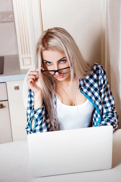 Portret van een vrouw met een laptop zittend aan de balie — Stockfoto