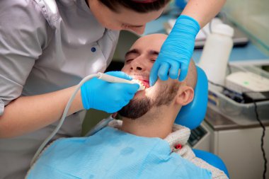 kadın diş hekimi yakın fotoğraf hastanın dişlerini kontrol eder 