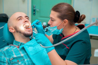 Male model treats teeth in dental office