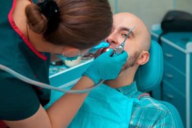 Young male checkups his teeth at the dentist doctor