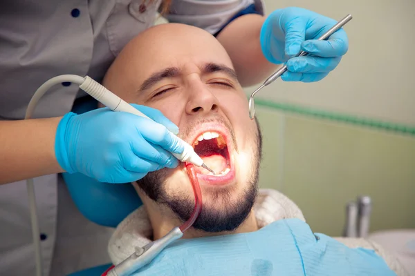 Primer plano foto de chico guapo trata dientes de caries en el dental —  Fotos de Stock