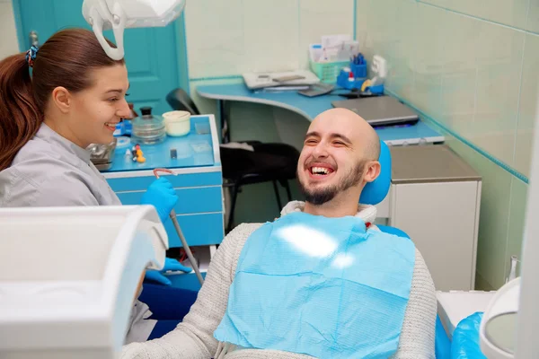 Οδοντίατρος που διασκεδάζει με τον ασθενή κατά τη διάρκεια της θεραπείας — Φωτογραφία Αρχείου