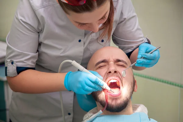 Dentista femenino con paciente masculino — Foto de Stock