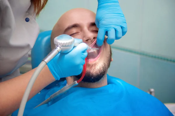 Человек лечит зубы у дантиста — стоковое фото