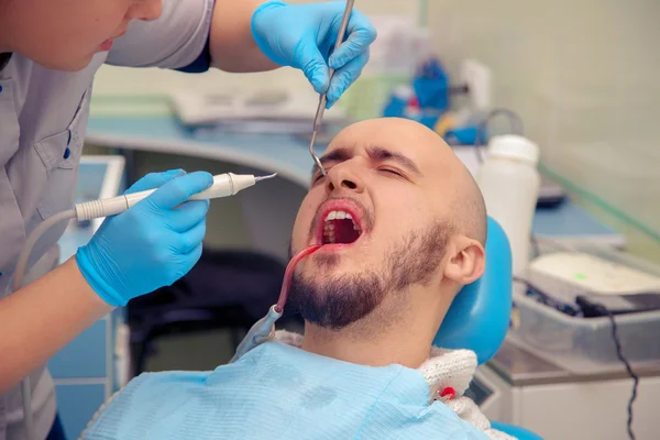 Hombre que sufre de un dolor de muelas en el dentista — Foto de Stock