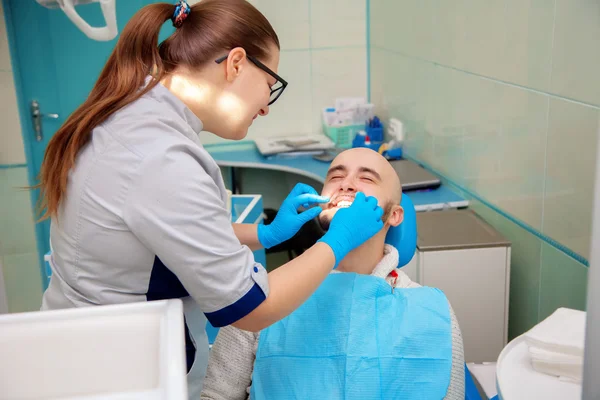 Nice adult guy on checking teeth in dental office — Stock Fotó