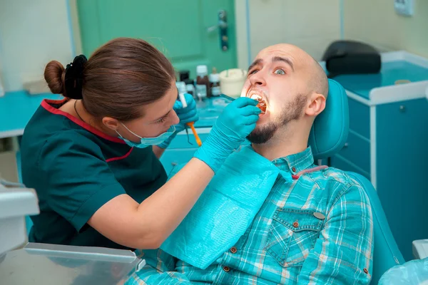 Foto dentista tratando los dientes al paciente — Foto de Stock