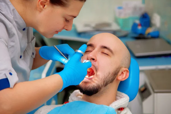 Professional dentist treats teeth patient — Stock fotografie