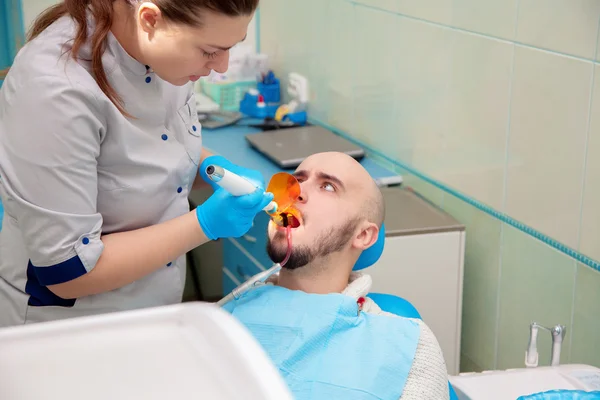 Scared guy in the dental office treats teeth — Stok fotoğraf