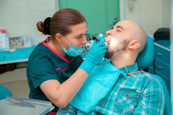 O tipo do dentista trata dos dentes. — Fotografia de Stock