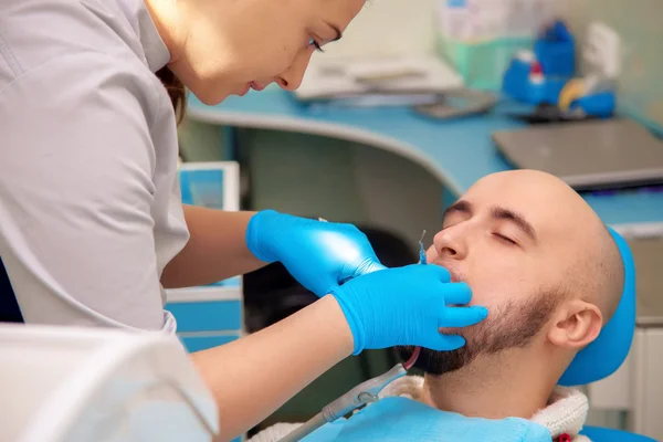 Woman dentist checks the teeth of her patient in the dental offi — Zdjęcie stockowe