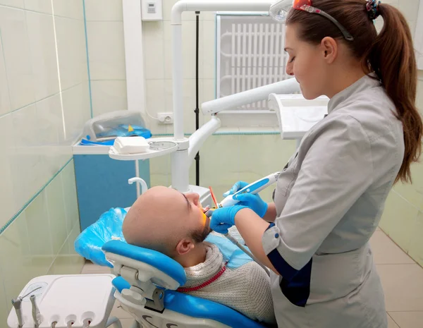 Young adult Woman dentist checks the teeth of her patient in the — Φωτογραφία Αρχείου