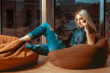 Moda model cep telefonu ile kanepede el ve bak poz