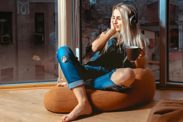 Moda sarışın genç kadın enjoing müzik kulaklık ile 