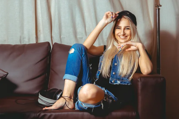 Divertente bella donna in abiti casual sorridente sulla macchina fotografica si siede — Foto Stock