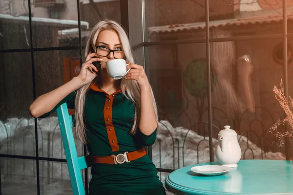 Business woman at coffee break talking phone and drinks tea