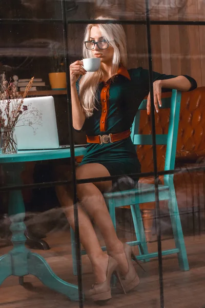 Het ung blond affärskvinna dricker kaffe i en city café — Stockfoto