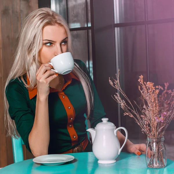 Retrato cuadrado de una joven rubia hermosa en un café con una — Foto de Stock