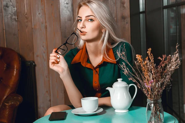 Śliczny biznes kobieta w kawiarni z filiżanką herbaty patrząc camer — Zdjęcie stockowe