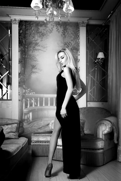 Ωραία ξανθιά σέξι γυναίκα στο μακρύ μαύρο φόρεμα και τα ψηλά τακούνια lookin — Φωτογραφία Αρχείου