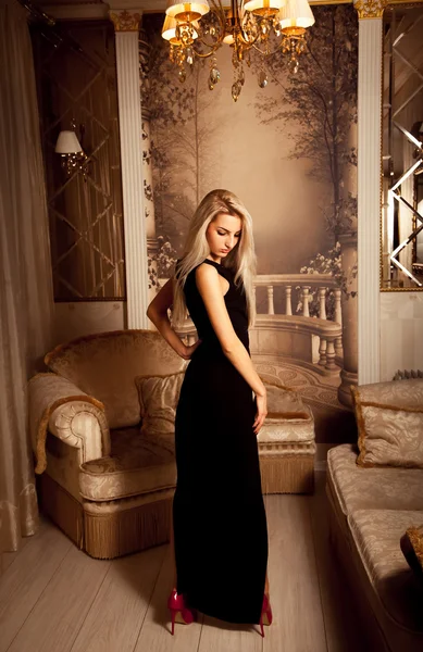 Стройная сексуальная блондинка в длинном черном платье и на красных каблуках — стоковое фото