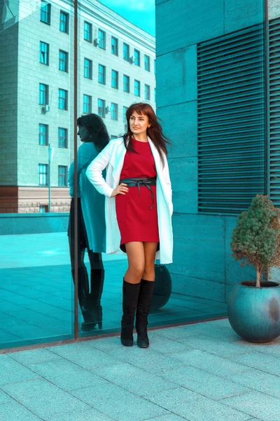 Aantrekkelijke volwassen brunette vrouw poseren naast de spiegel muur — Stockfoto