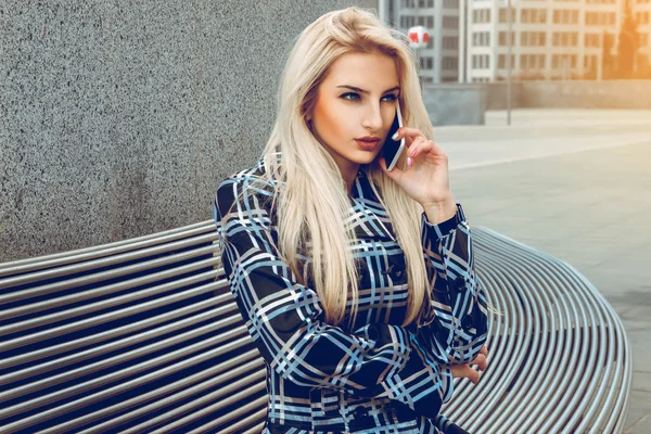 Ung vacker blond affärskvinna med blå ögon talar pho — Stockfoto