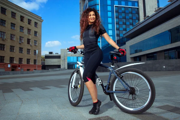 Alegre magro jovem mulher de esportes na bicicleta — Fotografia de Stock