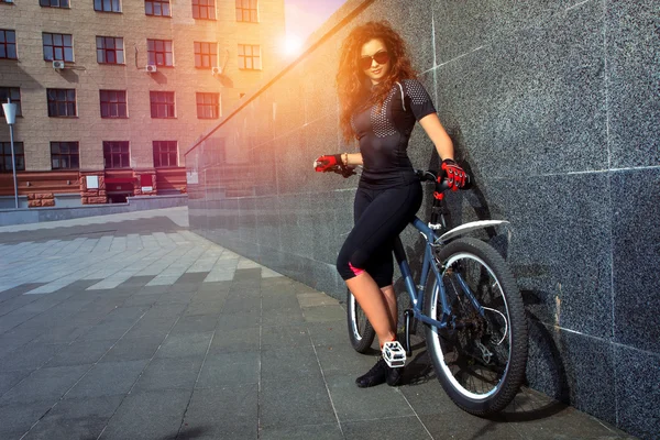 Bela jovem mulher com cabelo encaracolado vermelho na bicicleta — Fotografia de Stock