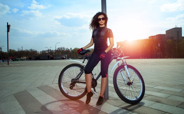 Glamour sport kvinna i solglasögon på cykel — Stockfoto