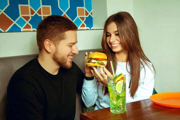 Lány etetés neki barátja hamburger — Stock Fotó