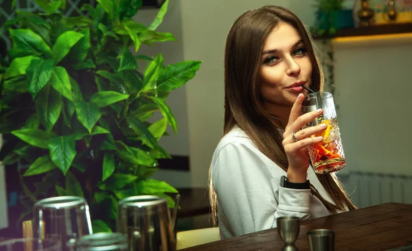 Vrouw met groene ogen kijken naar de camera en het drinken van cocktai — Stockfoto