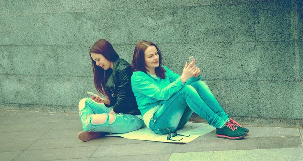 两个女孩坐在大街上 — 图库照片