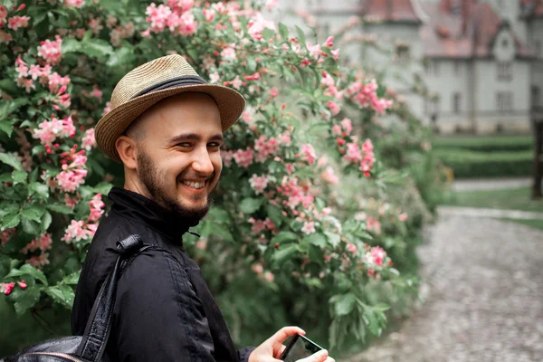 Man in a straw hat and with a beard looking at the camera and sm — Stock Photo, Image