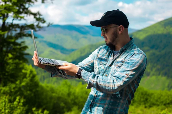 Man aan het werk op laptop in de mauntains — Stockfoto