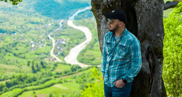 山の風景とポーズを後ろからサングラスの男 — ストック写真