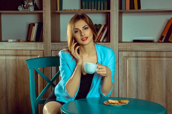 Młoda kobieta rozmawia przez telefon i picie herbaty — Zdjęcie stockowe