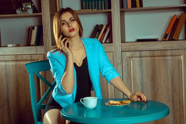 Portrait of young woman talking on the phone and drinking tea — Stock Photo, Image