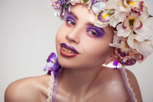 Happy young girl with wreath on head and makeup in purple tones — Stock Photo, Image