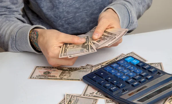 horizontal photo of the guy at the desk considers on the calcula