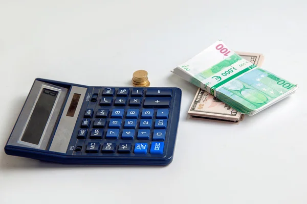 Євро і доларові гроші на столі поруч з калькулятором — стокове фото