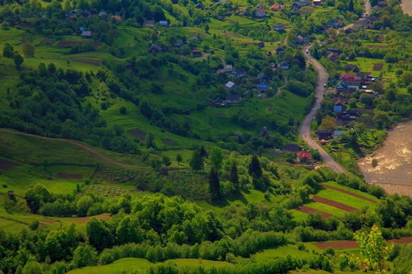 Kleines Dorf in der hügeligen Landschaft — Stockfoto