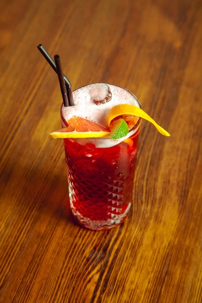 Red cocktail with orange and lime — Stock Photo, Image