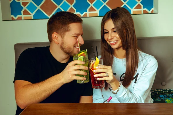 Couple in a cafe clink cocktails — Stock Photo, Image